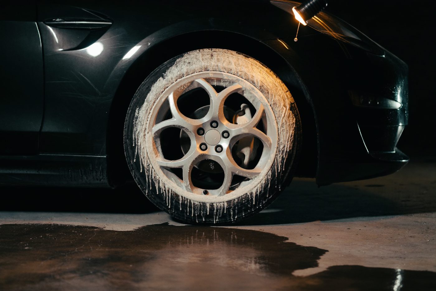 Detailed wheel and tire in a dark wash bay