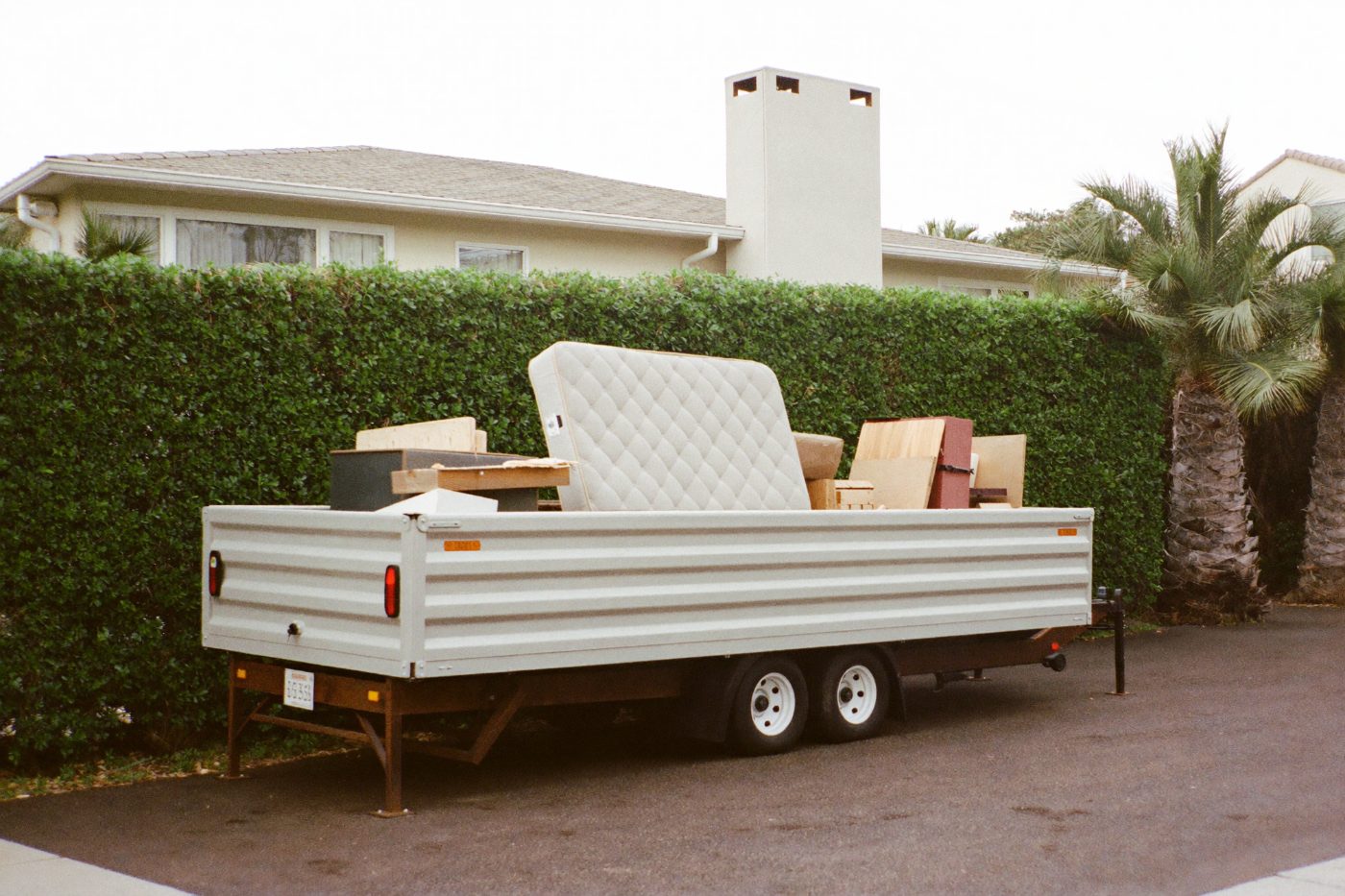 Dump trailer loaded with debris on a residential driveway